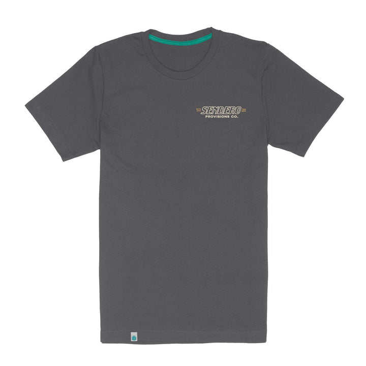 The Out Yonder T-Shirt by Sendero Provisions Co. is a plain dark gray, short-sleeve tee crafted from soft organic cotton, featuring the brand’s logo on the left chest and a small blue tag near the bottom hem.