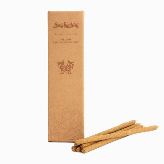A box of "Palo Santo Hand-Rolled Incense Sticks | Luna Sundara" stands upright beside four sustainably harvested hand-rolled incense sticks from Luna Sundara, all arranged on a white background.