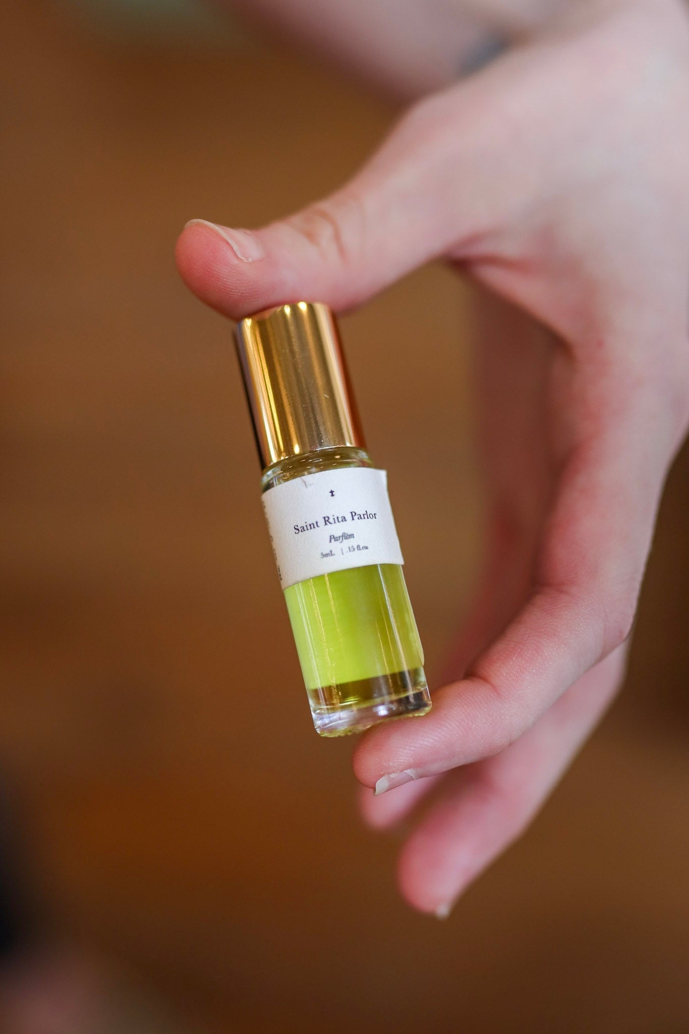 Hand Holding Bottle Of Saint Rita Parlor Perfume