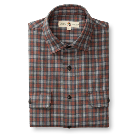 The Duck Head Performance Flannel Sport Shirt features gray, blue, and red plaid with black buttons and two front pockets, displayed folded on a white background—ideal as a moisture-wicking outdoor hiking or everyday shirt.