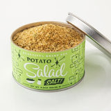 A round can with a green label reading "Potato Salad Salt | Beautiful Briny Sea" by Beautiful Briny Sea, filled with a yellowish seasoning blend perfect for grilled veggies or your favorite dishes.