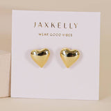 A pair of tarnish-free Puffed Gold Heart Earrings by JaxKelly, displayed on a white card labeled "JaxKelly Wear Good Vibes.