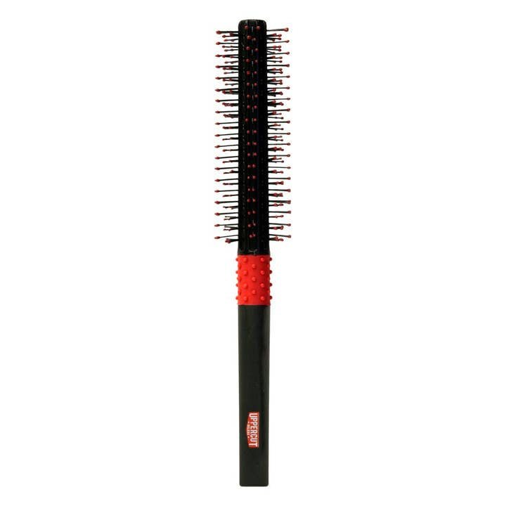 The Uppercut Deluxe Quiff Roller is a black and red hair styling brush with plastic bristles and a textured red grip, perfect for creating voluminous pompadour styles.