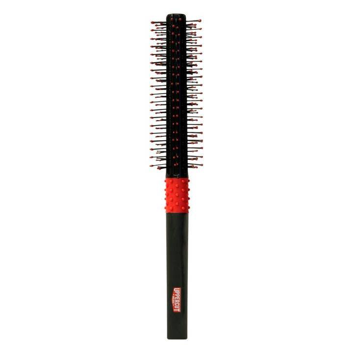 The Quiff Roller by Uppercut Deluxe is a black and red round styling brush with plastic bristles and a textured handle, shown standing upright against a white background.