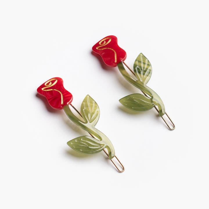The Winona Irene Red Rose Acetate Barrette Hair Clip Set features two cellulose acetate barrettes with red flower tops and green stems, shown on a white background.
