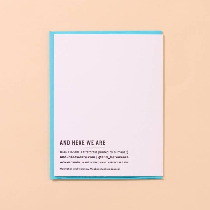 The Reel Good Birthday Card by And Here We Are is a white letterpress card with blue edges reading "AND HERE WE ARE" on the front, business and production info below, and a blank interior.