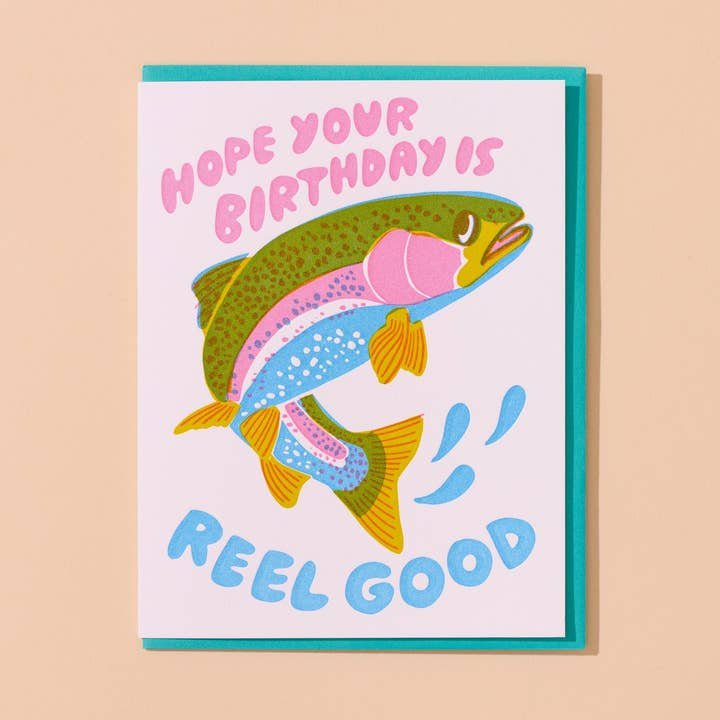The "Reel Good Birthday Card" by And Here We Are features a colorful rainbow trout and the pun “Hope your birthday is reel good”—a playful card for birthdays.