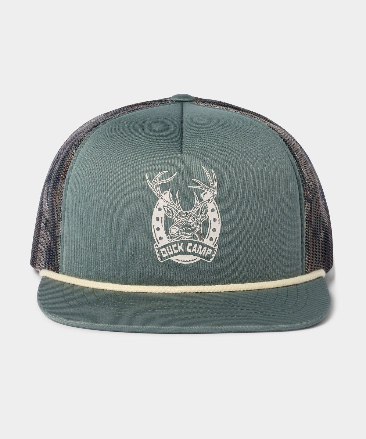 The Lucky Deer Hat by Duck Camp is a green trucker hat with a mesh back, cream rope detail, and a white antler-horseshoe "DUCK CAMP" logo on the front. Features an adjustable snapback for the perfect fit.