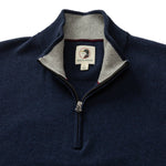 The Duck Head Ridley 1/4 Zip Sweater in navy blue features a gray inner collar and visible branding. Machine washable, this stylish sweater is shown laid flat with the zipper partially open for a casual, comfortable look.