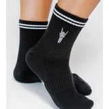 Person wearing Rock On Knit Ankle Sock By Loindaflow | Tailored Union—black ribbed ankle socks with white double stripes and a small white hand graphic, from Tailored Union.