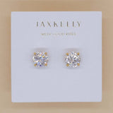 The JaxKelly Round CZ Earrings feature 18k gold-plated studs on a white card with "WEAR GOOD VIBES." Hypoallergenic for comfortable, everyday wear.
