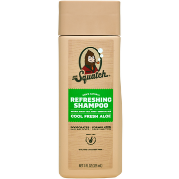 A beige bottle of Dr. Squatch Shampoo | Cool Fresh Aloe, enriched with soothing oat protein, features green and white labeling and the Dr.Squatch bearded character logo.