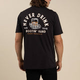 A person wears Sendero Provisions Co.'s Shootin' Hand black ultra-soft cotton tee, featuring a soft touch screen print of a skeleton hand with a drink and "Never Drink With Your Hootin' Hand" on the back.