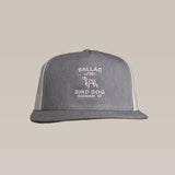 The Shop Hat by Ballad of the Bird Dog is a gray and white trucker hat with "Ballad of the Bird Dog Brenham, TX" and a dog outline embroidered on front—ideal for those who value style and comfort.