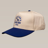 The Ballad of the Bird Dog Shop Hat | Field Companion is a beige and navy blue cap featuring an embroidered dog graphic and "Ballad of the Bird Dog Texas" text on the front.