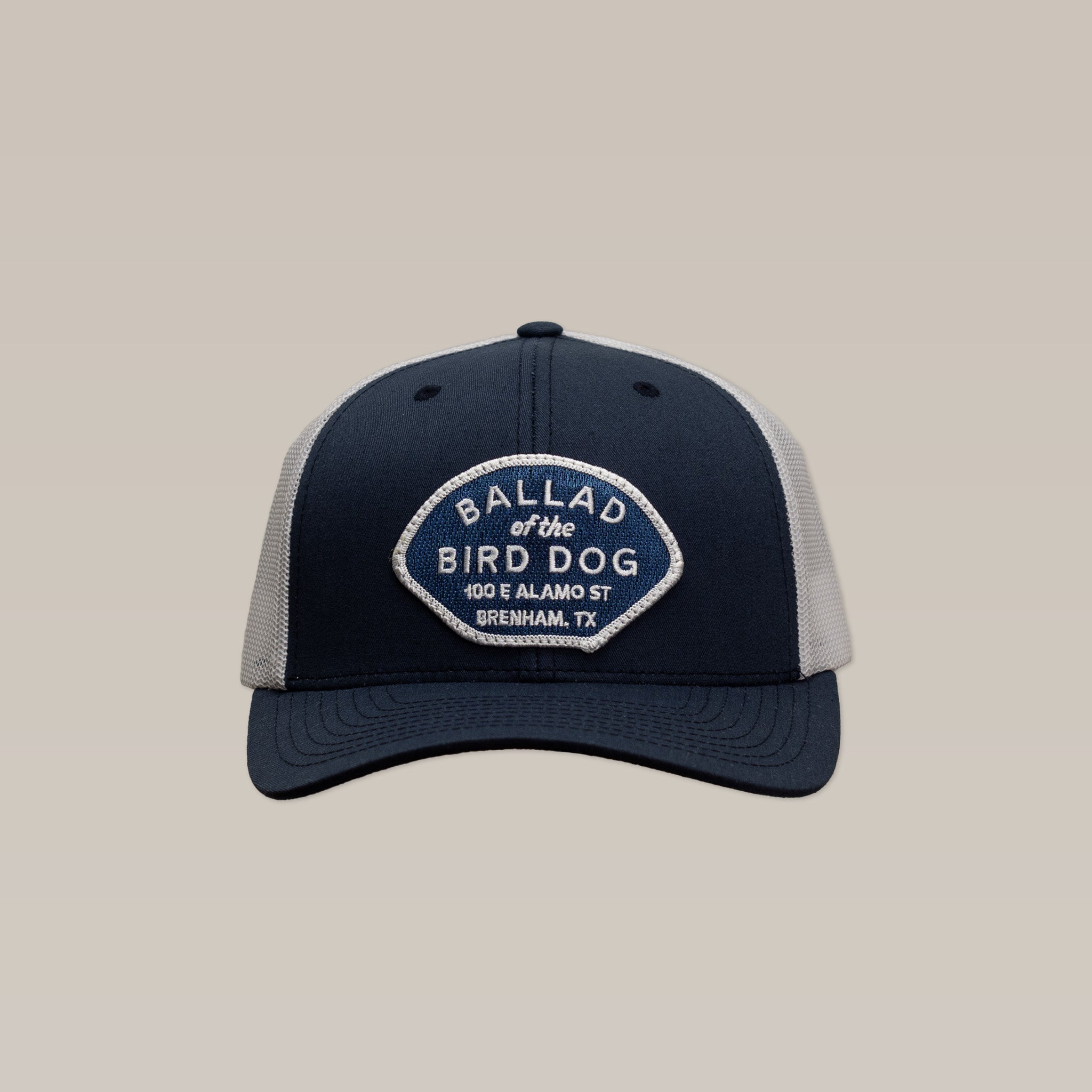 The Ballad of the Bird Dog Shop Hat | Home Base features a navy and gray mesh design with a patch reading “Ballad of the Bird Dog, 100 E Alamo St, Brenham, TX”—perfect for showing local pride and supporting small business.