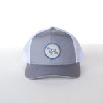 The Ballad of the Bird Dog Shop Hat | Merit Badge is a gray and white snapback baseball cap with mesh back and a blue circular bird dog patch on the front.