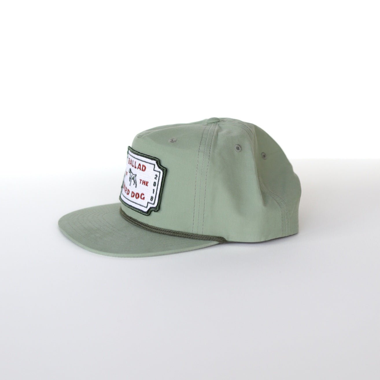 The Shop Hat | Neon Revival by Ballad of the Bird Dog features a light green flat brim and a rectangular embroidered patch—ideal for showing your style in downtown Brenham.