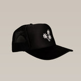 The Shop Hat | Peace Flower by Ballad of the Bird Dog features black mesh and three white embroidered peace flowers on the front—a stylish accessory to elevate any outfit.
