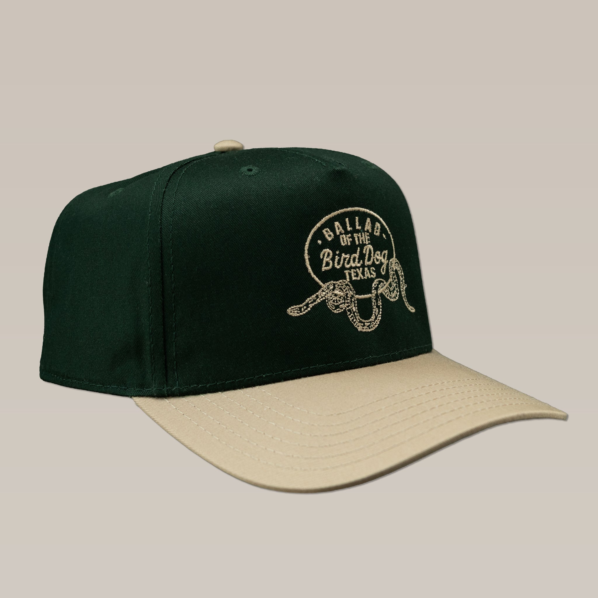 The Ballad of the Bird Dog Shop Hat features a green and beige Rattlesnake Oval Logo design, with "Ballad of the Bird Dog Texas" and a coiled rattlesnake graphic—perfect for fans of stylish snake-themed hats.