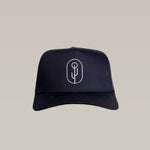 The Shop Hat | Simple Saguaro by Ballad of the Bird Dog is a black baseball cap with a white minimalist saguaro logo, embroidered on the front and shown against a plain beige background.