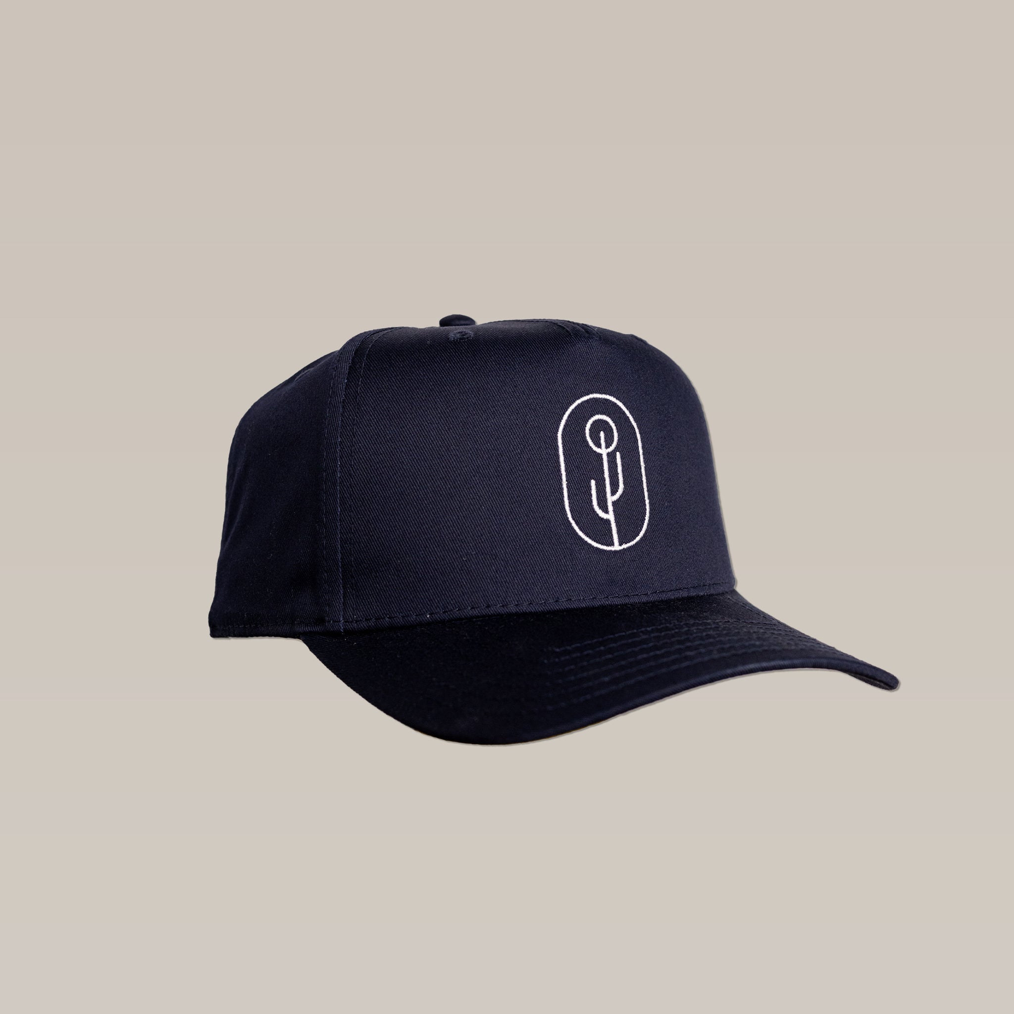 The Shop Hat | Simple Saguaro by Ballad of the Bird Dog is a black cap with a white minimalist embroidered saguaro cactus logo on the front, shown against a plain beige background.
