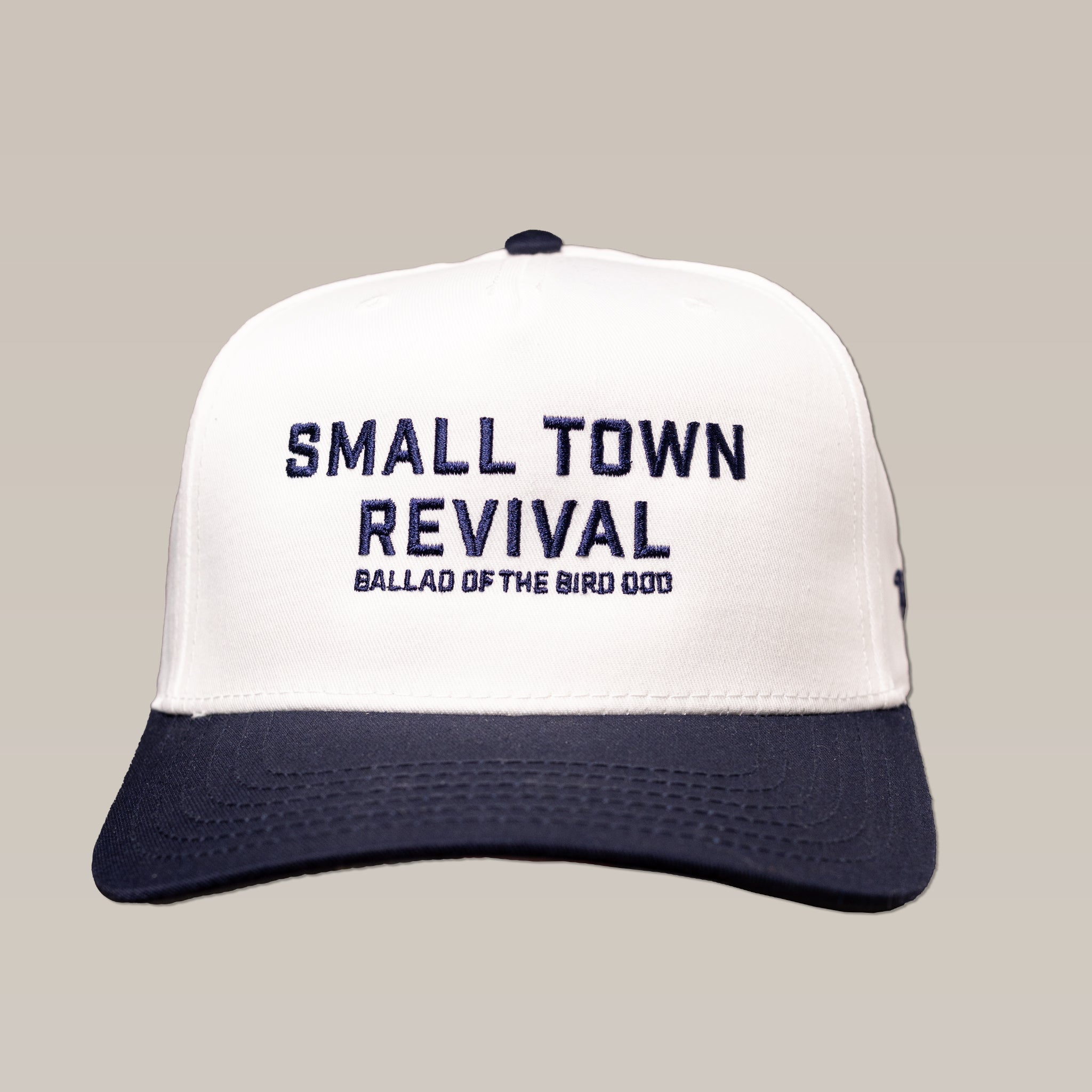 The Ballad of the Bird Dog Shop Hat features "Small Town Revival" embroidered on the front in white and navy.