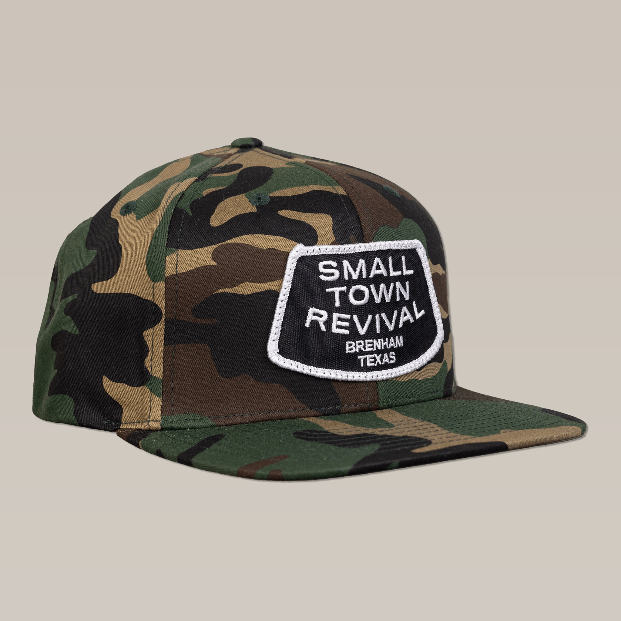 Show your Brenham pride with the Ballad of the Bird Dog Shop Hat, featuring a camouflage design and a white-edged "Small Town Revival Brenham Texas" patch—ideal for fans of small town hats.