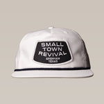 The Ballad of the Bird Dog Shop Hat features a white cap with a black "SMALL TOWN REVIVAL BRENHAM TEXAS" patch—ideal for fans of Brenham or unique small town hats.