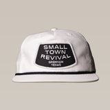 The Ballad of the Bird Dog Shop Hat features a white cap with a black "SMALL TOWN REVIVAL BRENHAM TEXAS" patch—ideal for fans of Brenham or unique small town hats.
