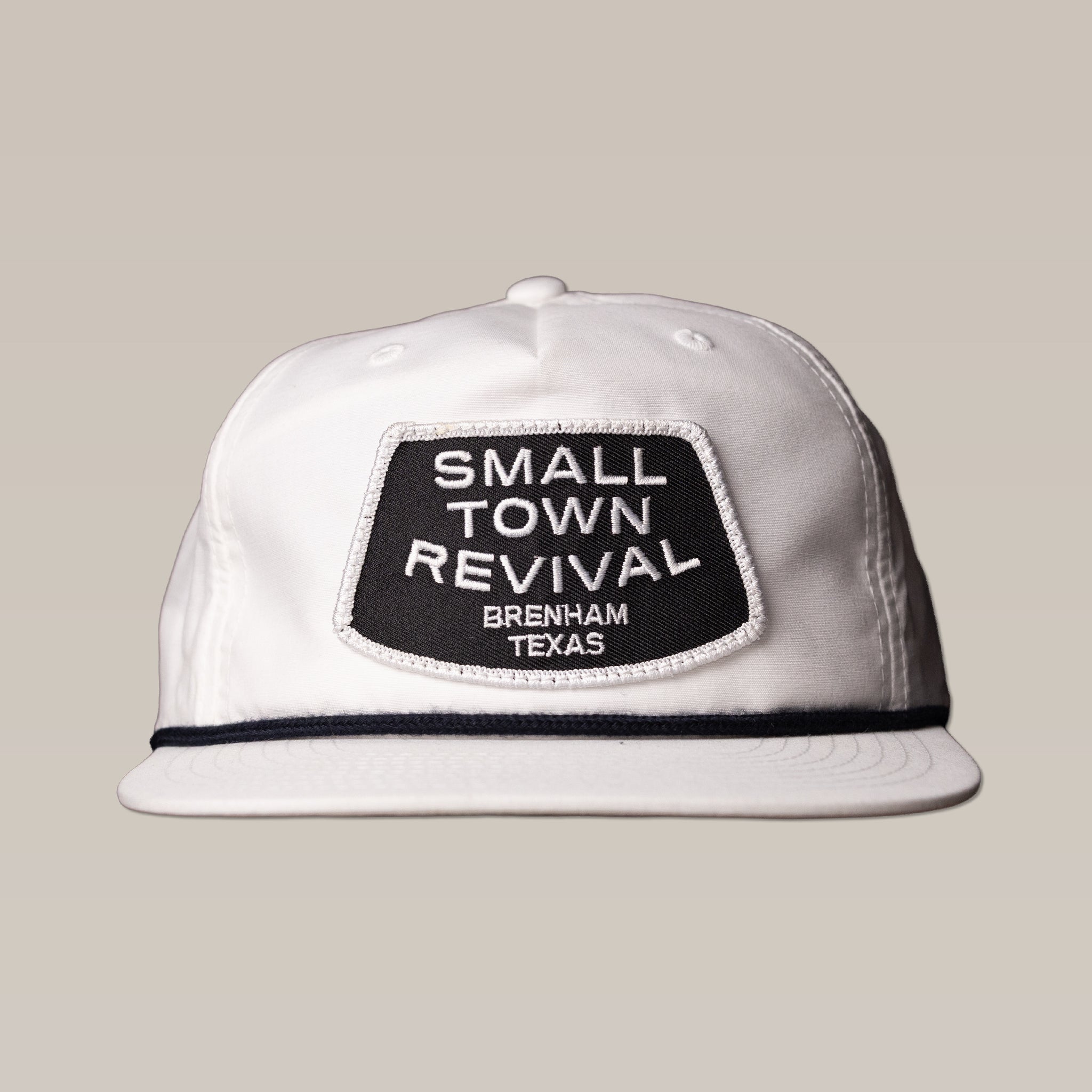 The Ballad of the Bird Dog Shop Hat features a white cap with a black "SMALL TOWN REVIVAL BRENHAM TEXAS" patch—ideal for fans of Brenham or unique small town hats.
