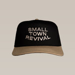 The Ballad of the Bird Dog Shop Hat features "SMALL TOWN REVIVAL" stitched in white on an unstructured black and tan cap with an adjustable snapback for comfort.
