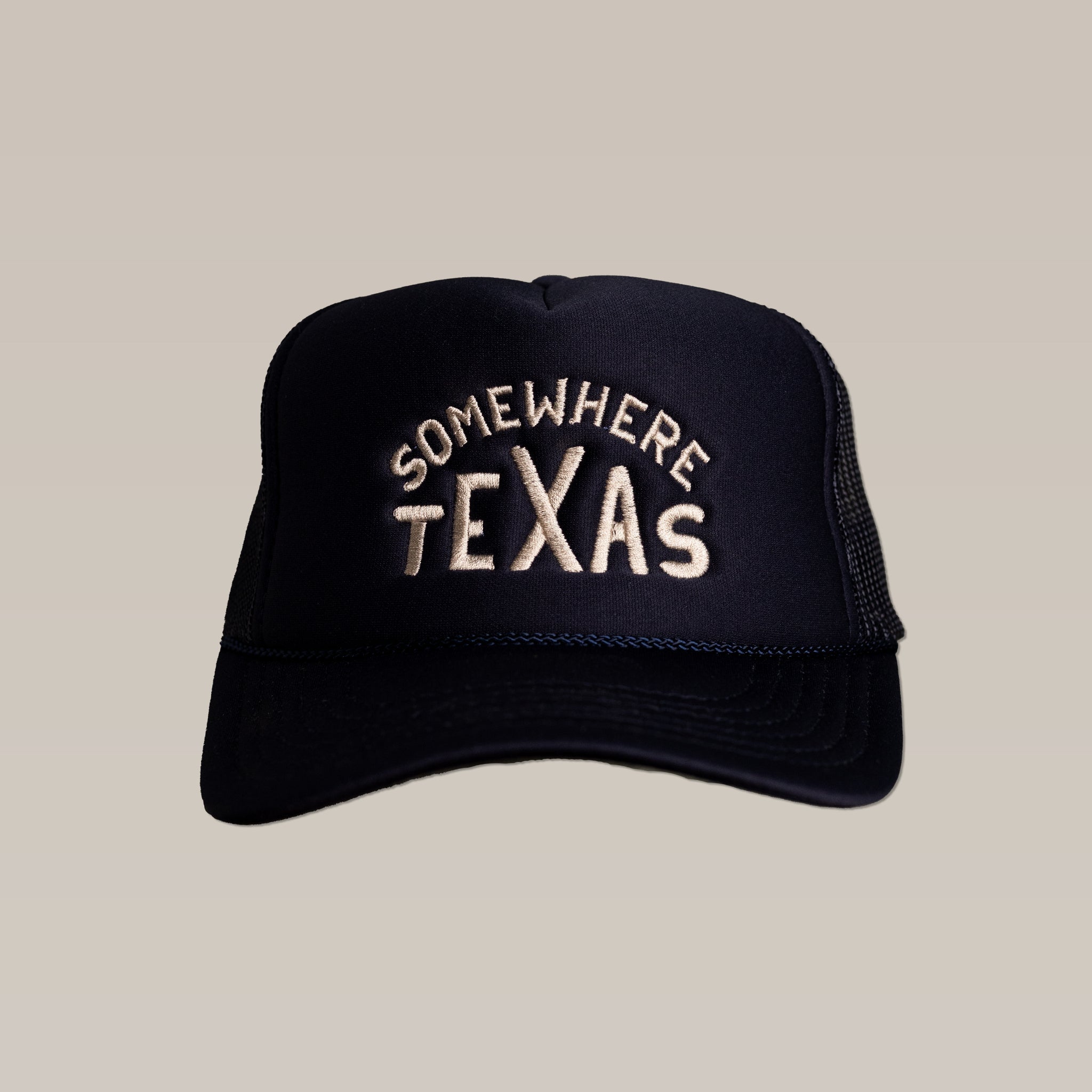 The Ballad of the Bird Dog Shop Hat is a black mesh snapback trucker hat featuring "SOMEWHERE TEXAS" in off-white embroidery on the front.