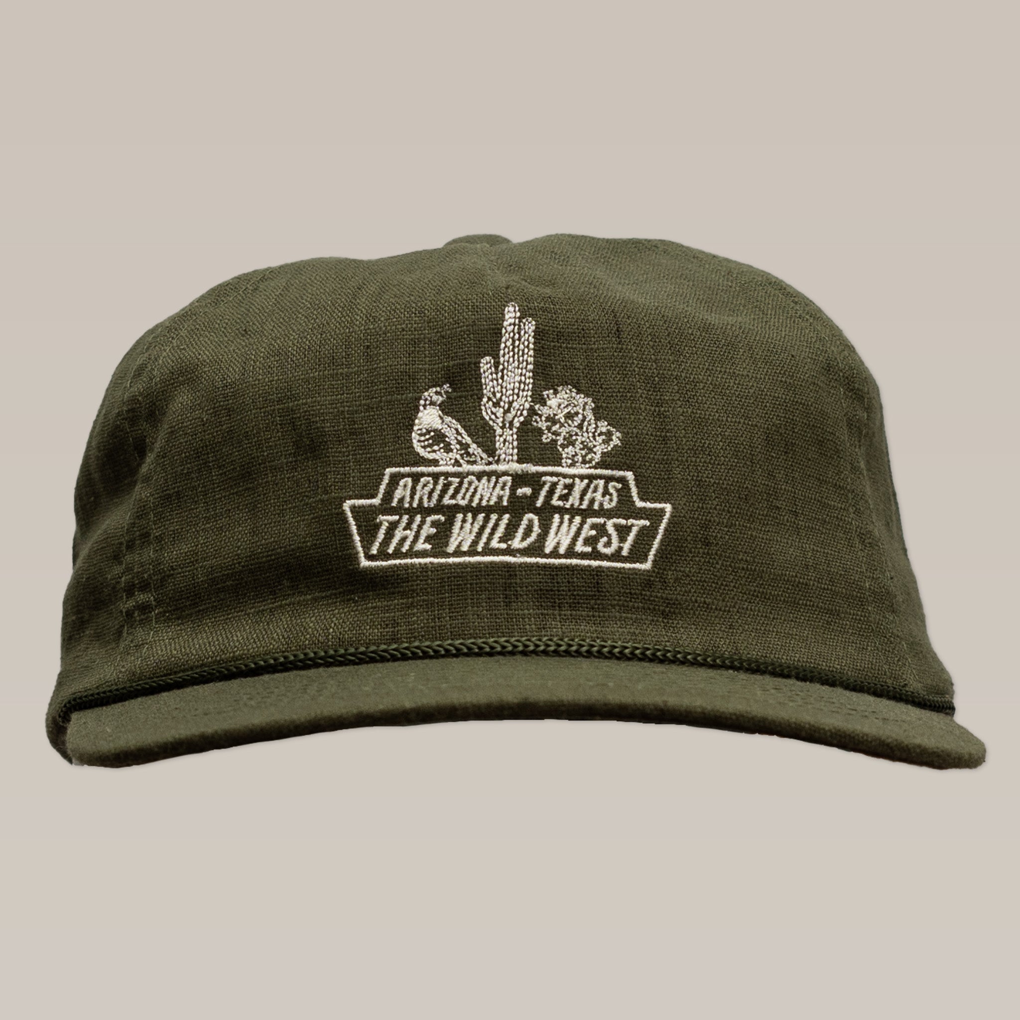 The Shop Hat | The Wild West by Ballad of the Bird Dog is an olive green cap with white embroidery—a bird, cactus, shrub, and "Arizona-Texas The Wild West"—and is part of our handcrafted desert hat series.