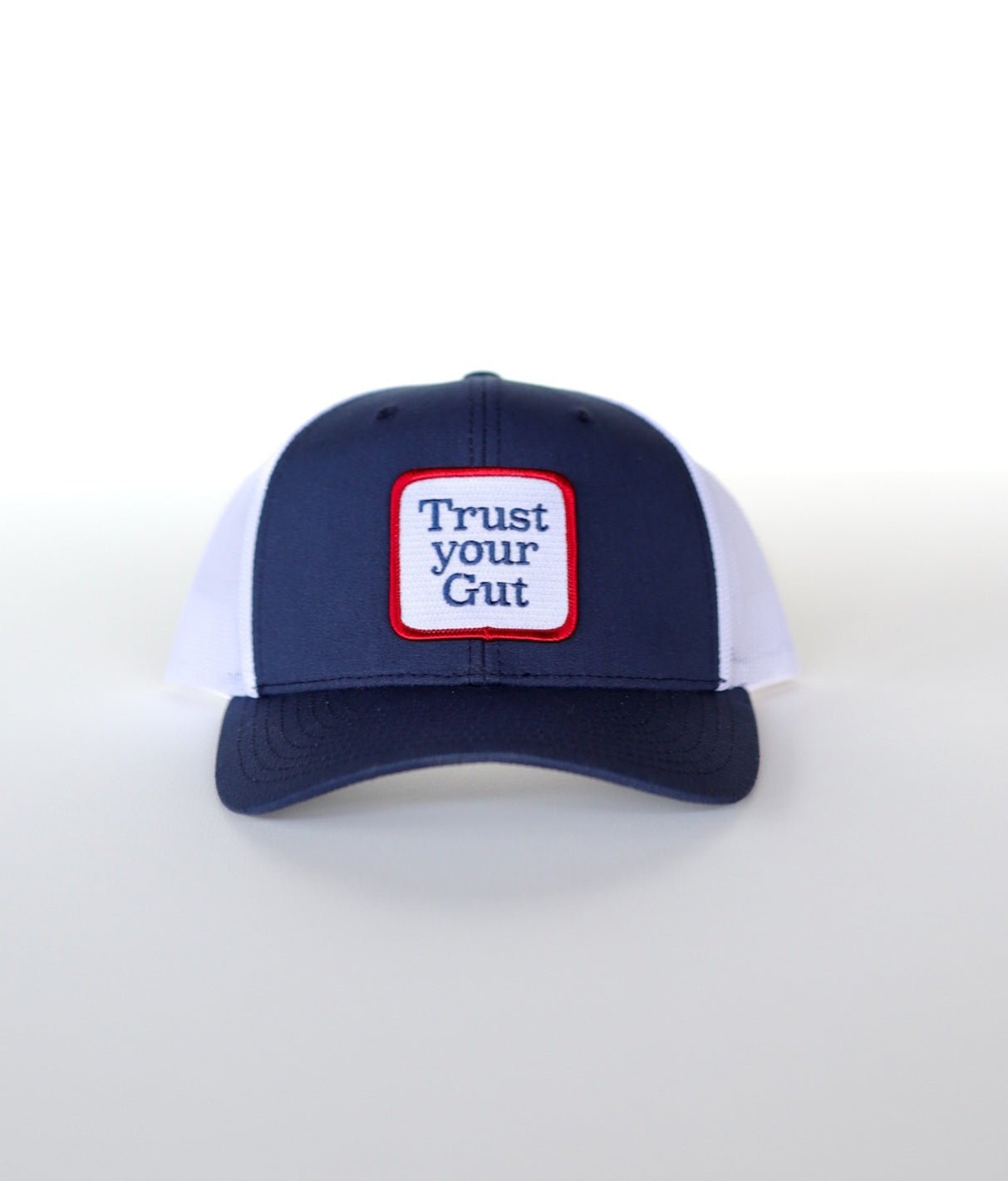 The Shop Hat | Trust Icon by Ballad of the Bird Dog features a blue and white design with a bold white patch, perfect for those who trust their intuition.