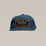 The Ballad of the Bird Dog Shop Hat | Trust Your Gut Vintage Slate is a blue baseball cap featuring a bold white and yellow "BALLAD of the BIRD DOG 'TRUST YOUR GUT'" patch on the front.