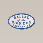 The Shop Patch | Classic Oval by Ballad of the Bird Dog features “Ballad of the Bird Dog, Brenham, TX” in blue on a light background with blue trim—a timeless patch for outdoor fans.