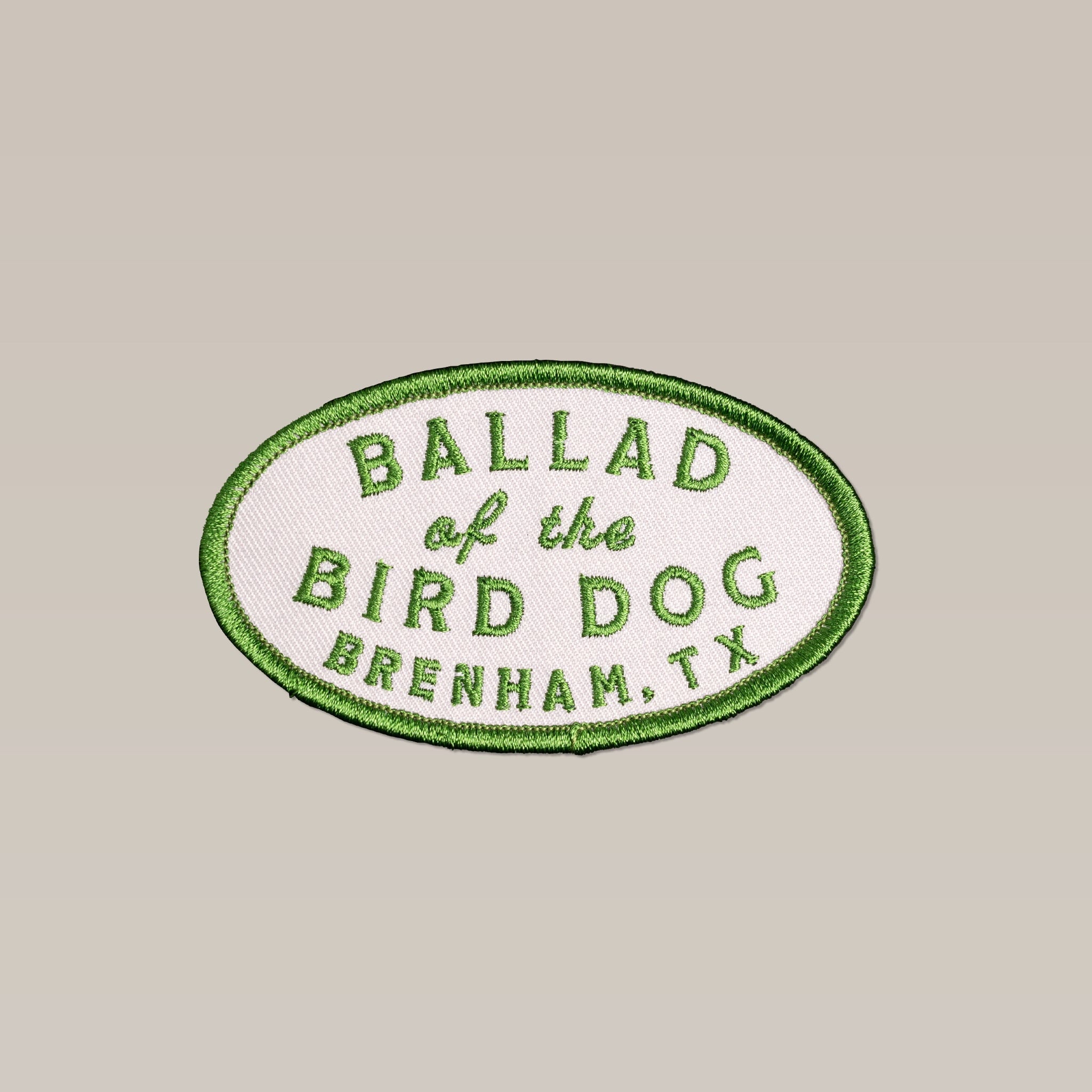 The Shop Patch | Classic Oval by Ballad of the Bird Dog features "Ballad of the Bird Dog, Brenham, TX" in green on white with a green border—ideal for outdoor lovers and fans of the classic patch style.