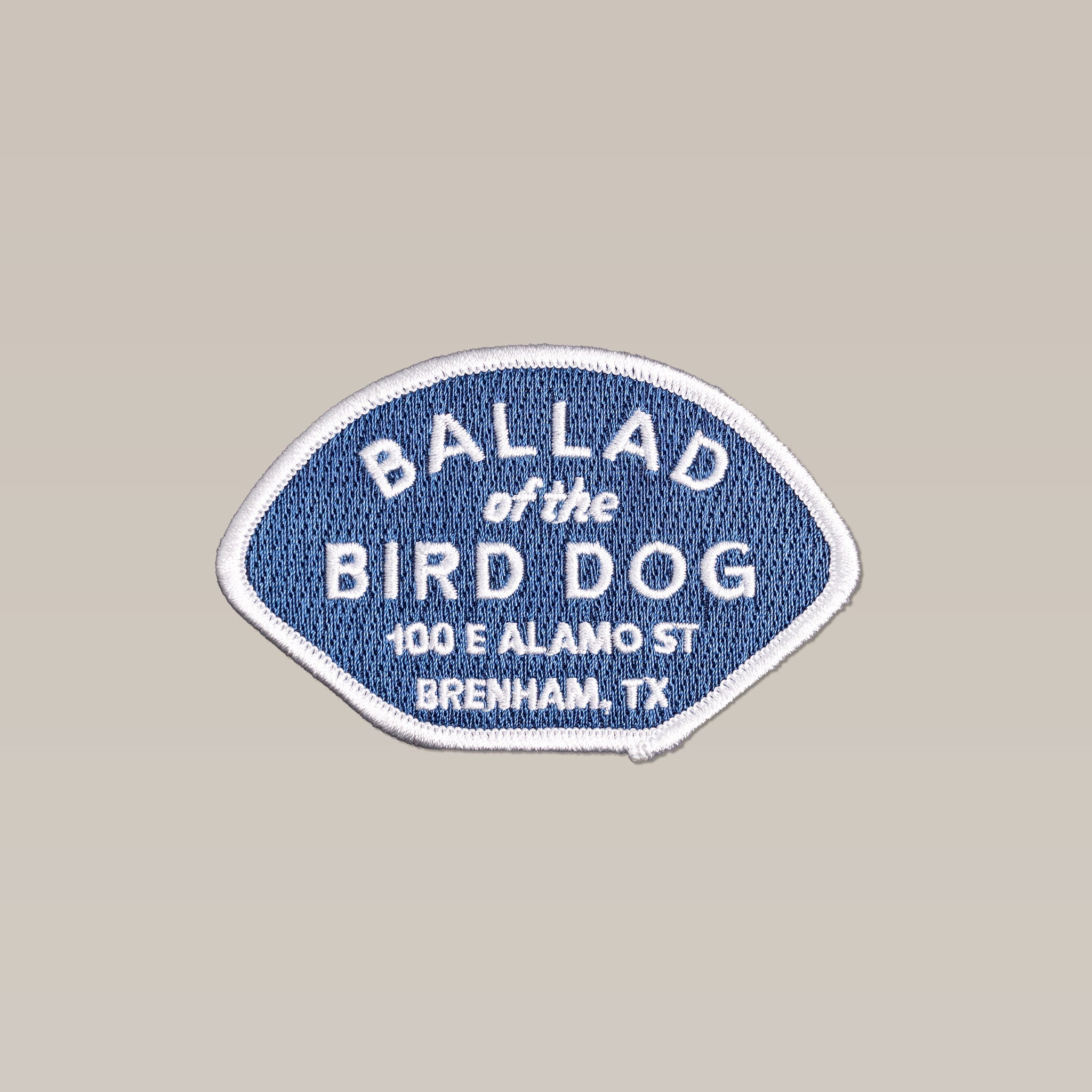 The Shop Patch | Home Base by Ballad of the Bird Dog features a blue background with white text: "Ballad of the Bird Dog, 100 E Alamo St, Brenham, TX," celebrating this local favorite.