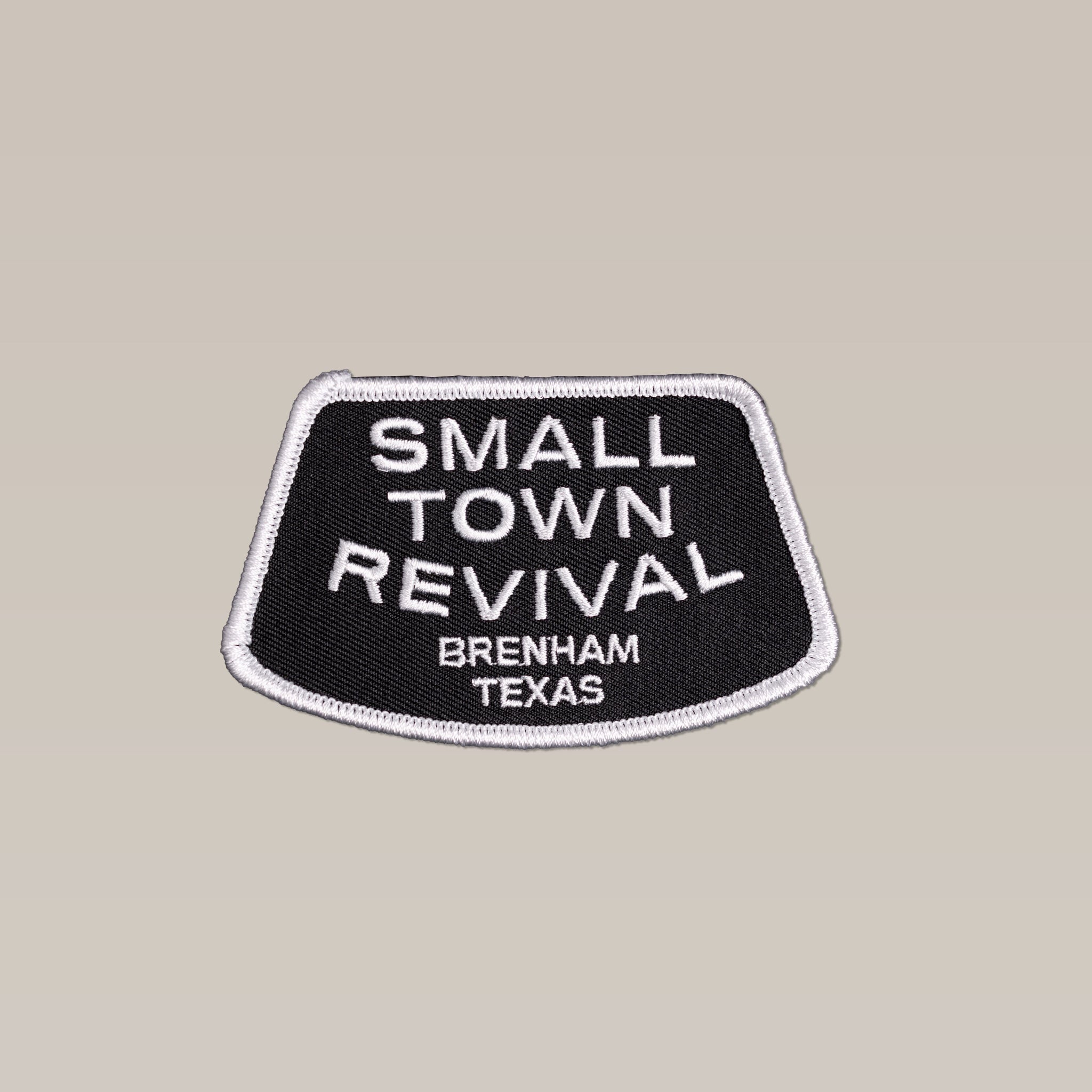 The Shop Patch by Ballad of the Bird Dog features "SMALL TOWN REVIVAL BRENHAM TEXAS" in black and white embroidery, perfect for anyone who supports or celebrates small towns.