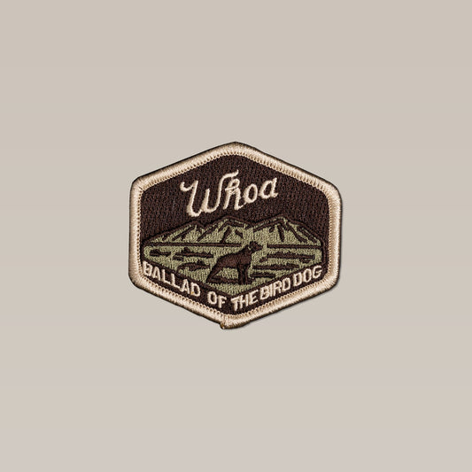 The Shop Patch | Whoa by Ballad of the Bird Dog features a hexagonal design with a mountain and dog silhouette, "Whoa" at the top, and "Ballad of the Bird Dog" at the bottom—ideal for bird hunting fans.