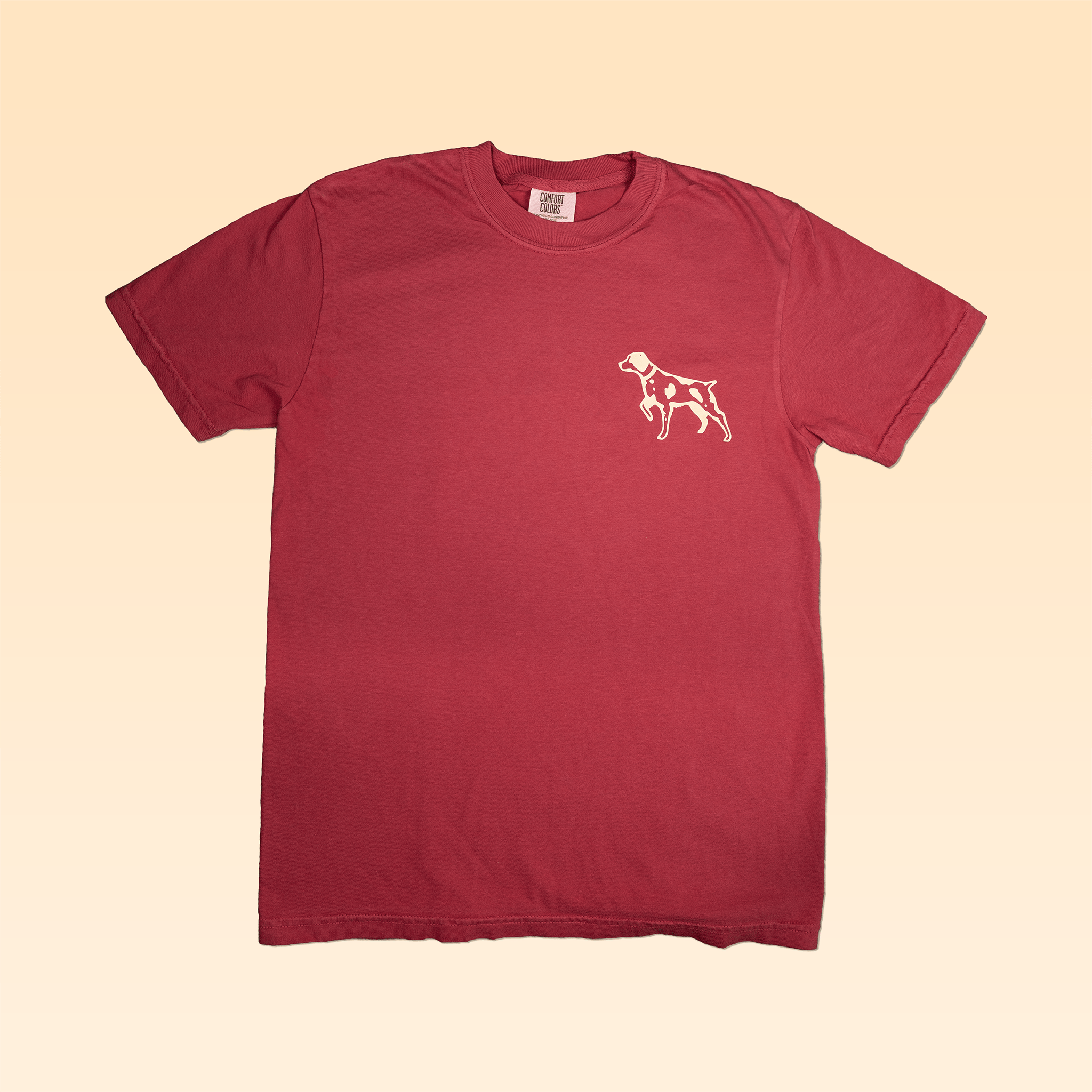 Show your love for the outdoors with the Shop Shirt | Bird Dog Badge by Ballad of the Bird Dog—a vintage-inspired red tee featuring a classic dog design.