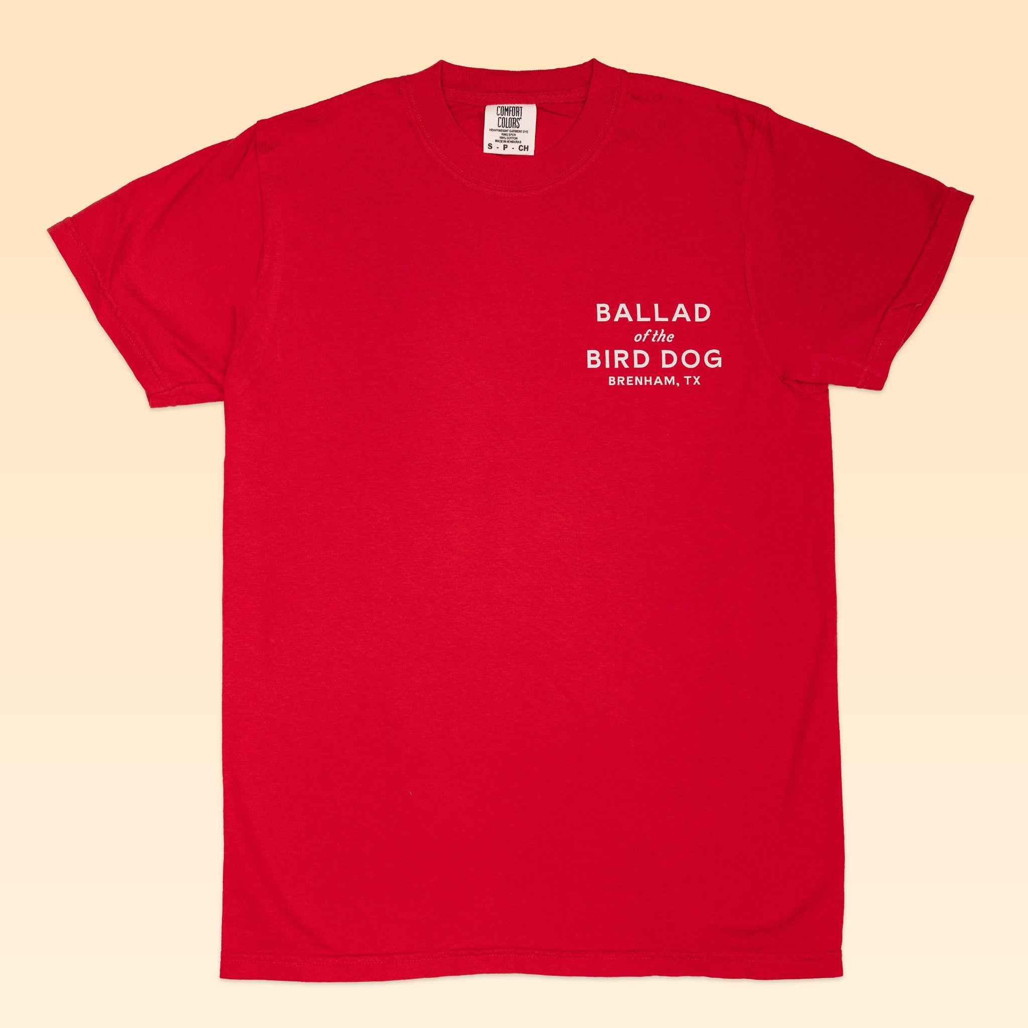 Ballad of the Bird Dog Shop Shirt: Red short-sleeve tee featuring the Classic Shop Logo, "BALLAD of the BIRD DOG BRENHAM, TX," printed in white on the upper left chest.