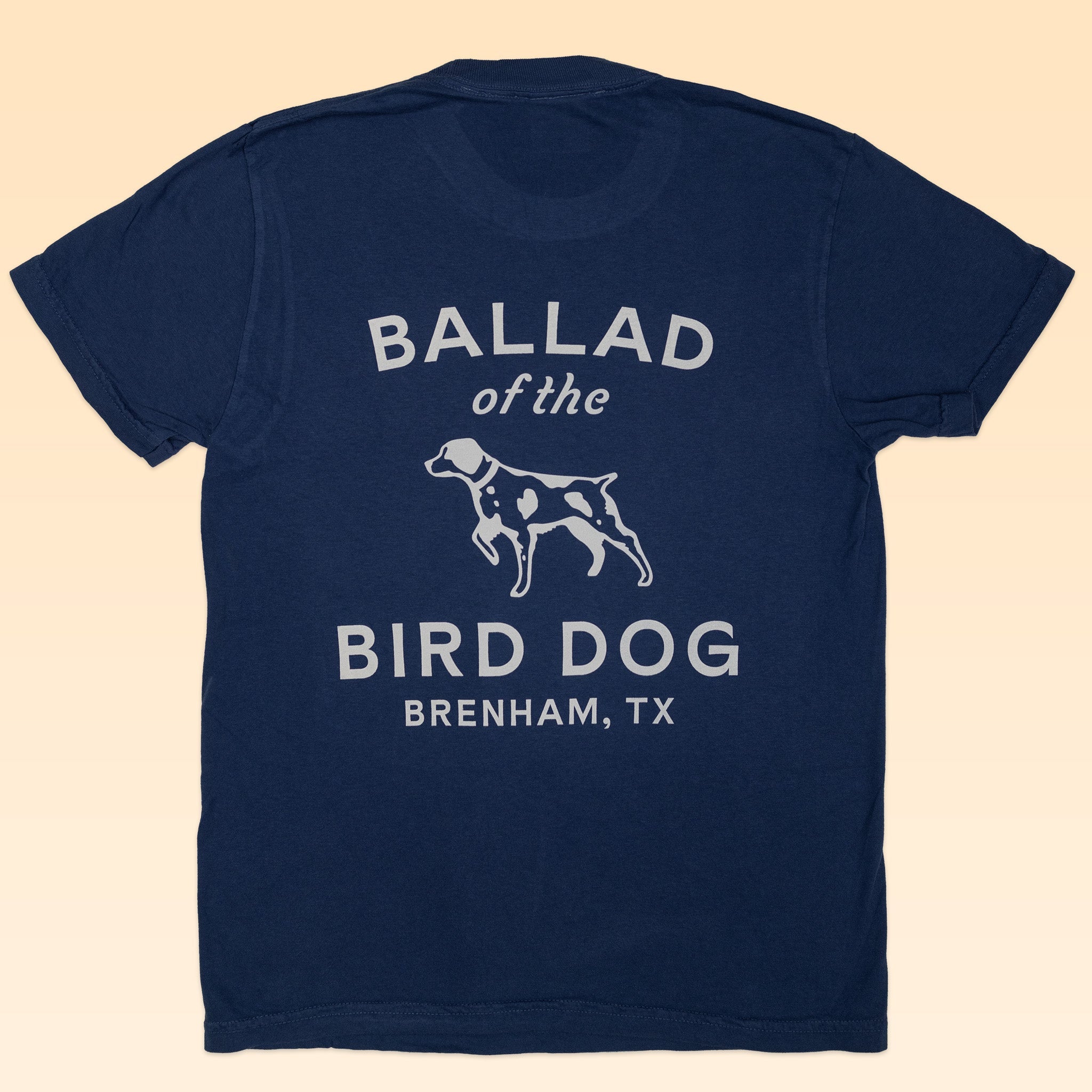 The Shop Shirt | Bird Dog Classic Shop Logo from Ballad of the Bird Dog features white text on blue organic cotton, combining comfort with style.