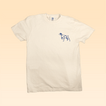 Shop Shirt | Bird Dog Legend by Ballad of the Bird Dog: white tee featuring a small blue outline dog on the left chest, set against a peach gradient—ideal for fans of vintage hunting shirt style.