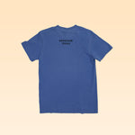 The Shop Shirt | Brenham Water Tank by Ballad of the Bird Dog is a blue short-sleeve tee laid flat, viewed from the back, featuring "BRENHAM TEXAS" in black near the neckline—a great way to show your local pride.