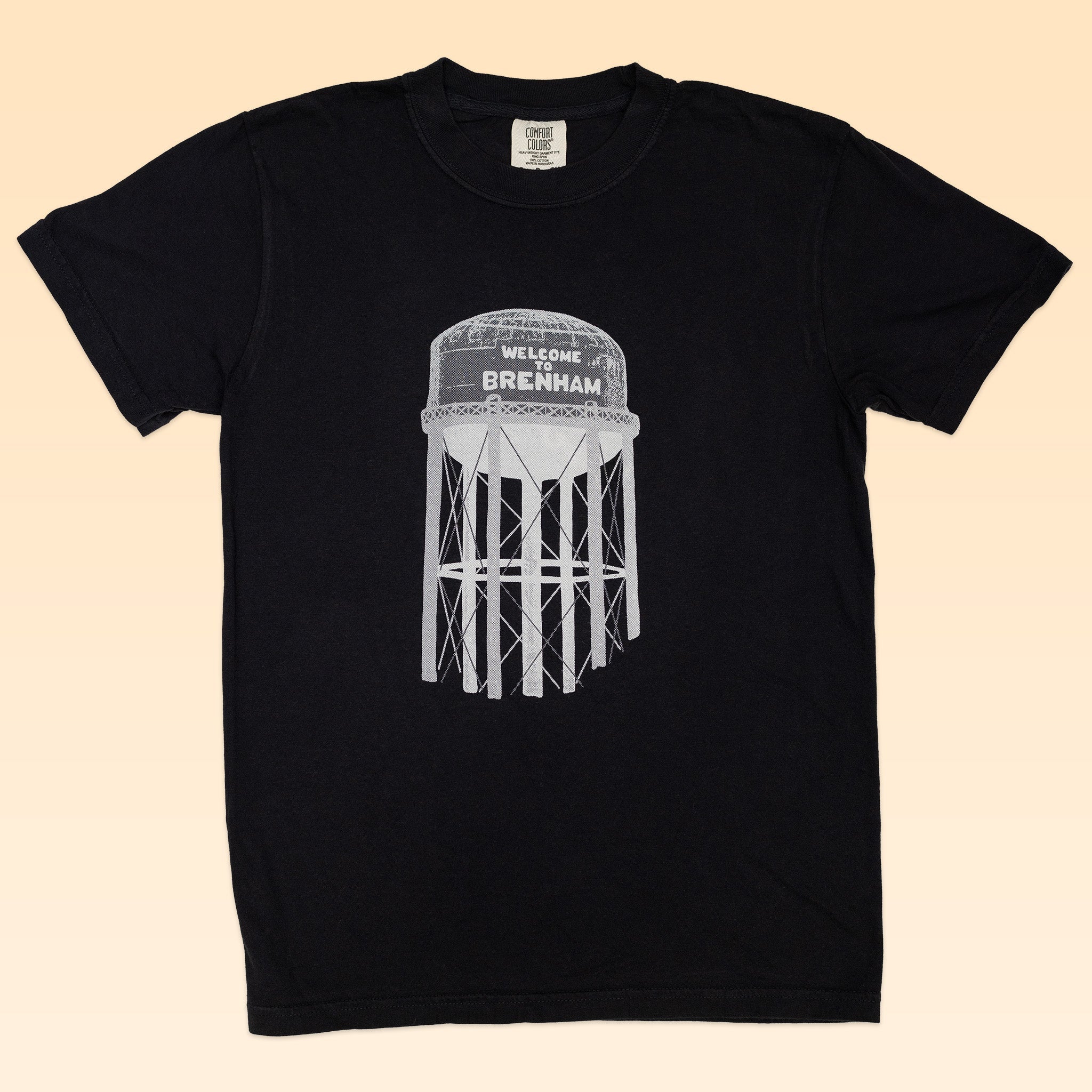 Show your Brenham pride with the Shop Shirt by Ballad of the Bird Dog—a black tee featuring a white "Welcome to Brenham" water tank graphic. Perfect for fans of the iconic Brenham Water Tank.