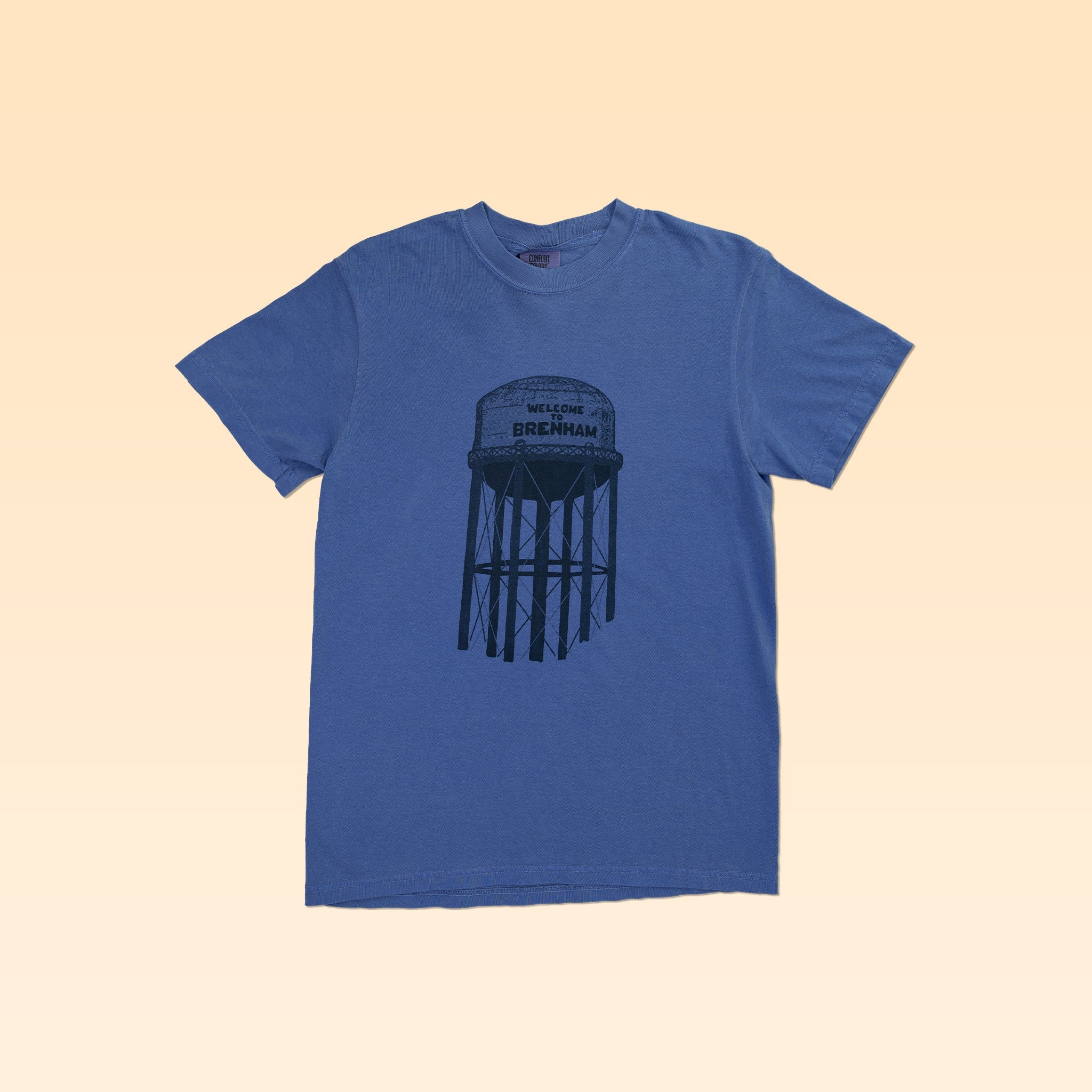Show your local pride with the Ballad of the Bird Dog Shop Shirt | Brenham Water Tank, featuring a graphic of Brenham's water tower and "Welcome Brenham" on the front.