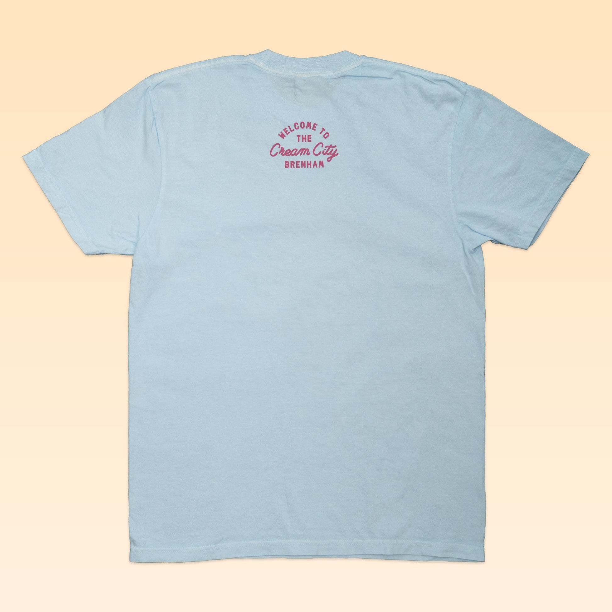 The Shop Shirt | Cream City by Ballad of the Bird Dog is a light blue shirt featuring pink "Welcome to the Cream City Brenham" text near the neckline, celebrating Brenham—home of Blue Bell Creameries.