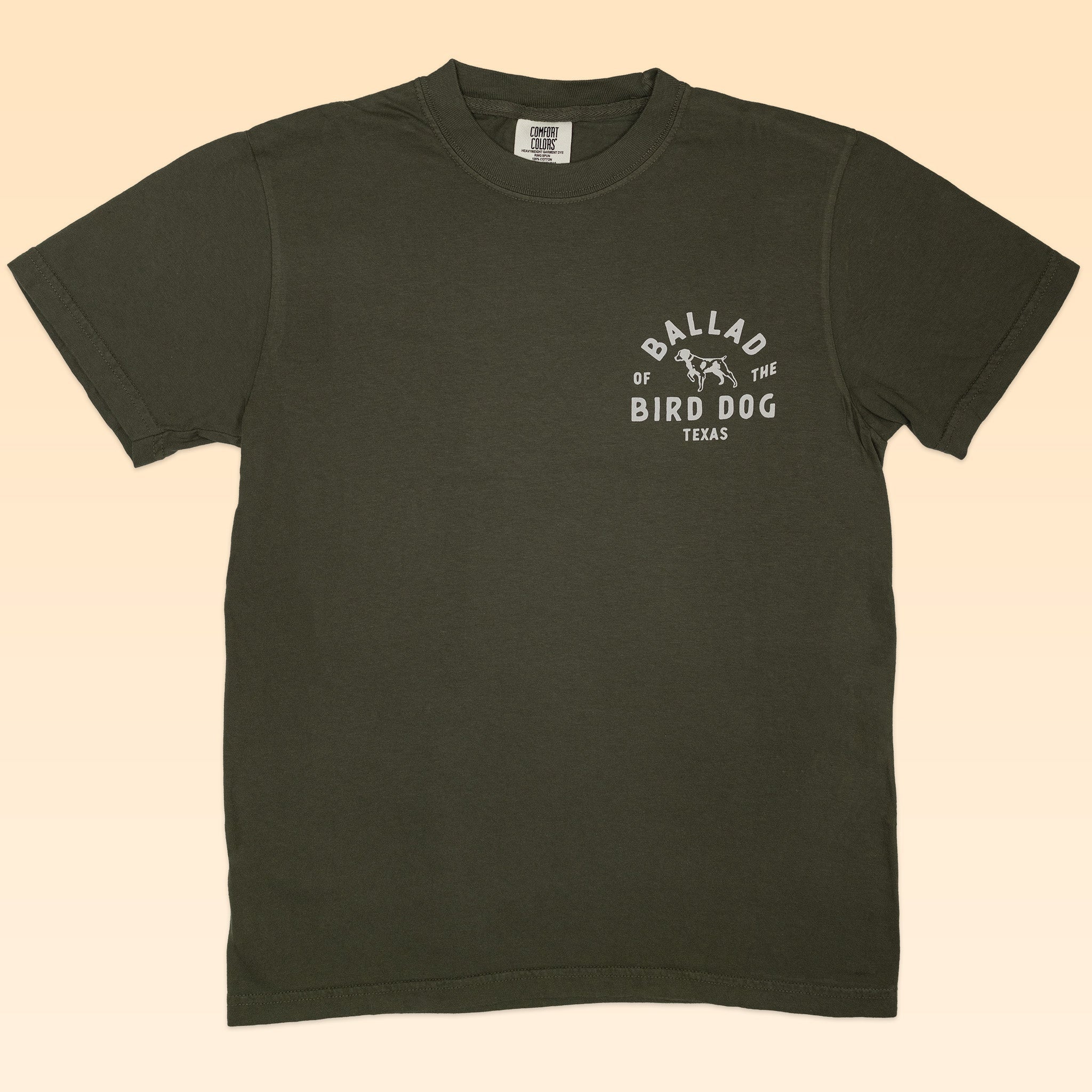 The Shop Shirt | Desert Covey Flush by Ballad of the Bird Dog is an olive green, hand-printed outdoor tee featuring a small white "Ballad of the Bird Dog Texas" graphic with a dog illustration on the left chest.